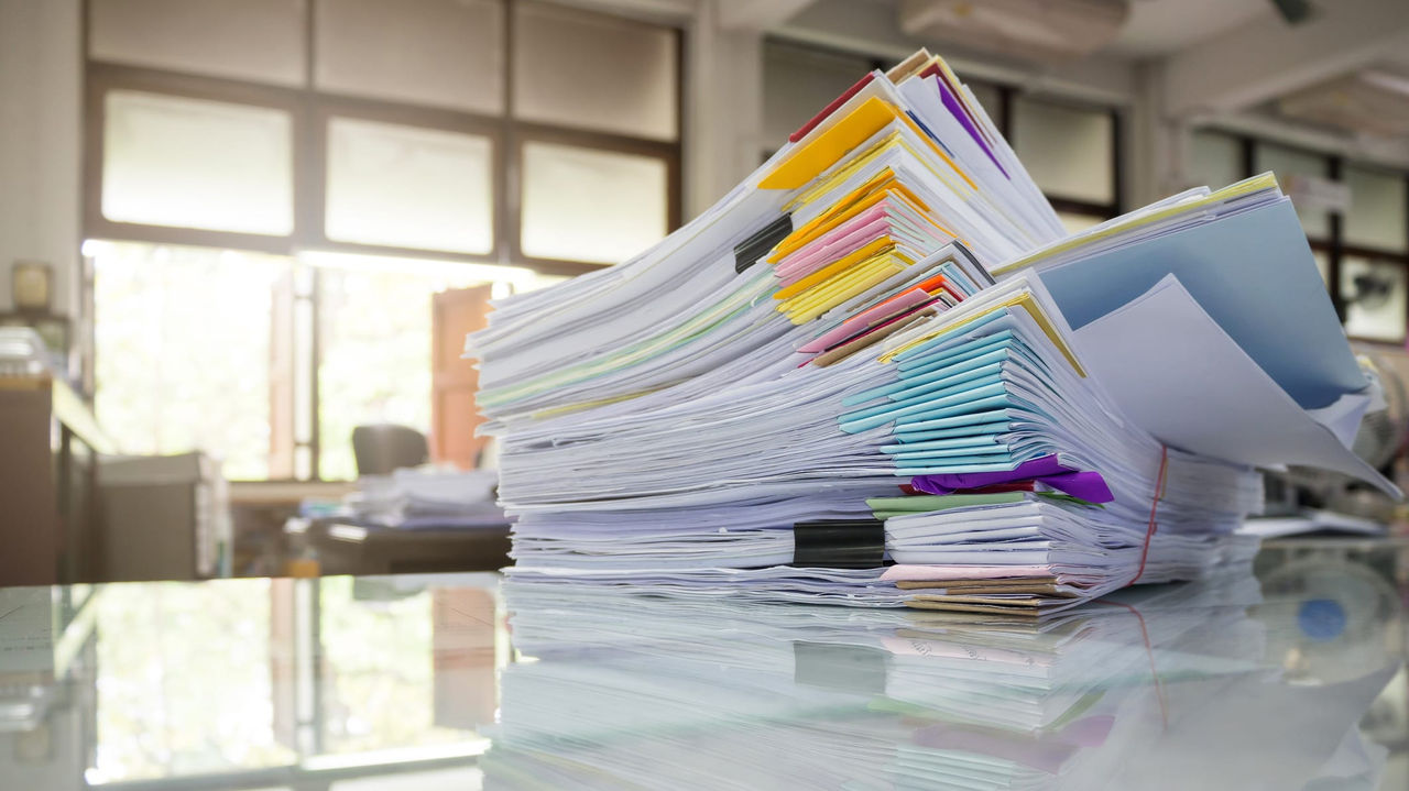 A stack of papers on a table in an office.