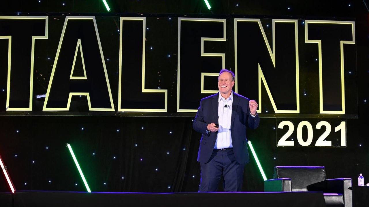 A man standing in front of a sign that says talent 2021.