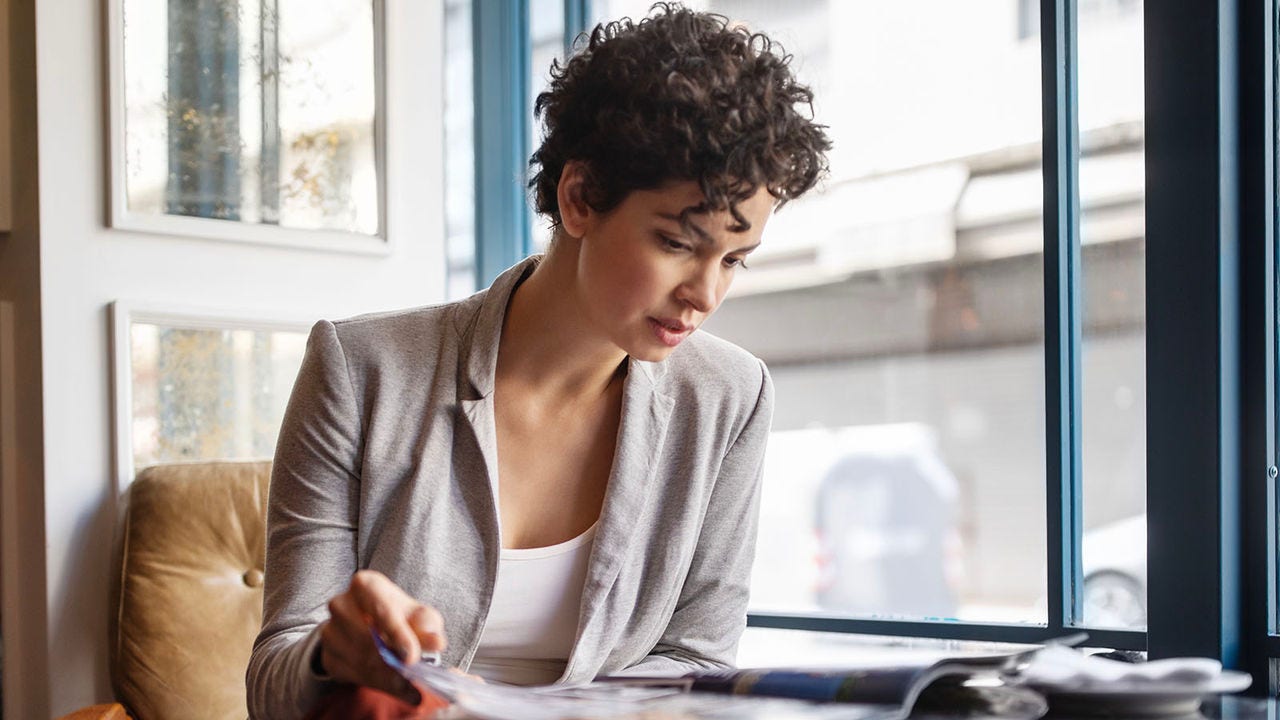 Female Human Resources executive reading HR Magazine in a coffee shop