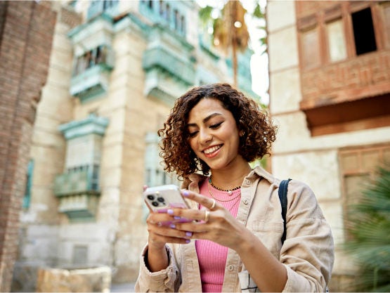 woman smiles while looking at cellphone