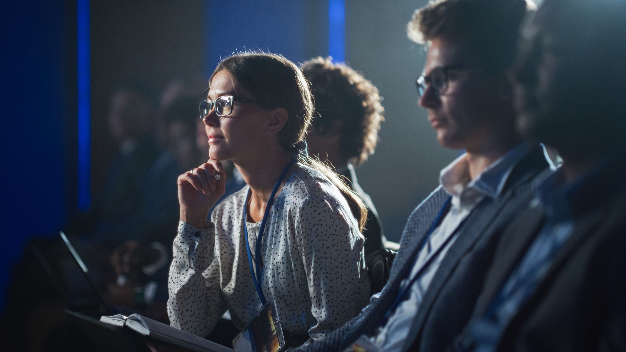 Executive listens intently at a speaker event.