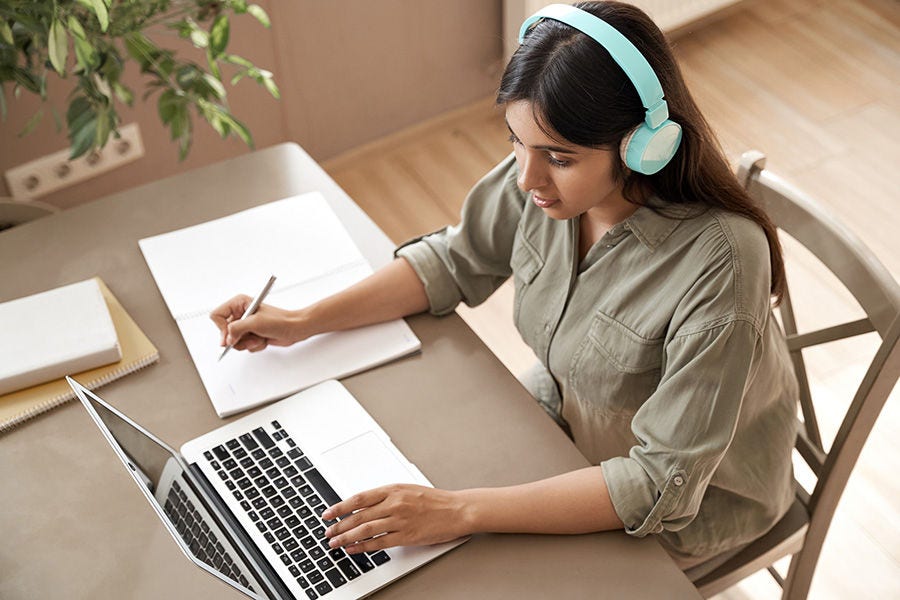 Worker taking notes from an online training course