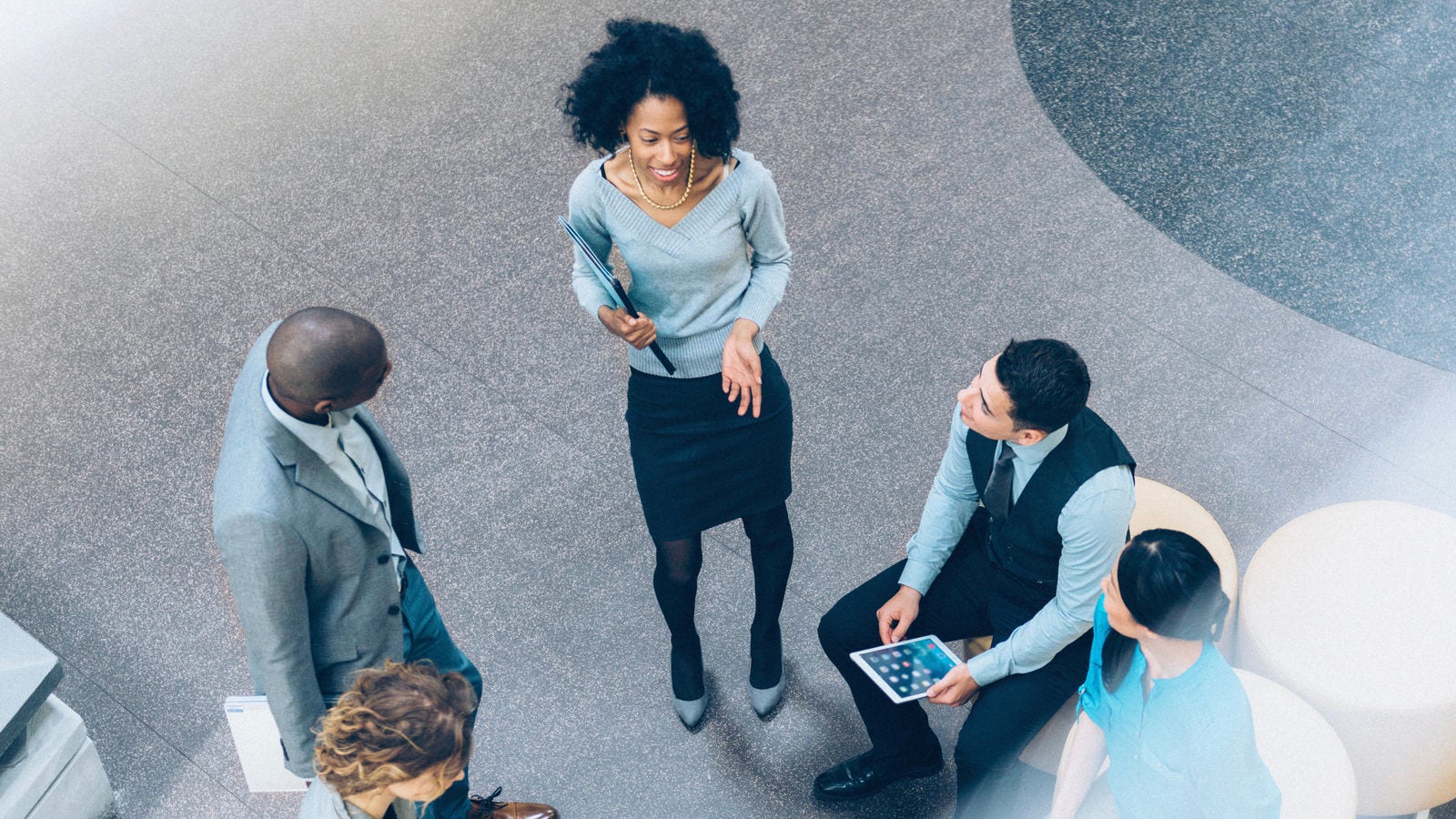 Group of diverse professionals discussing business in an office setting from an overhead vantage point