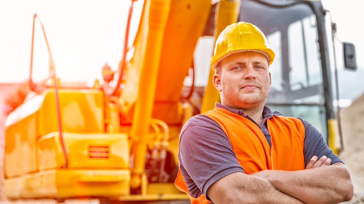 construction worker man crosses arms posing for camera