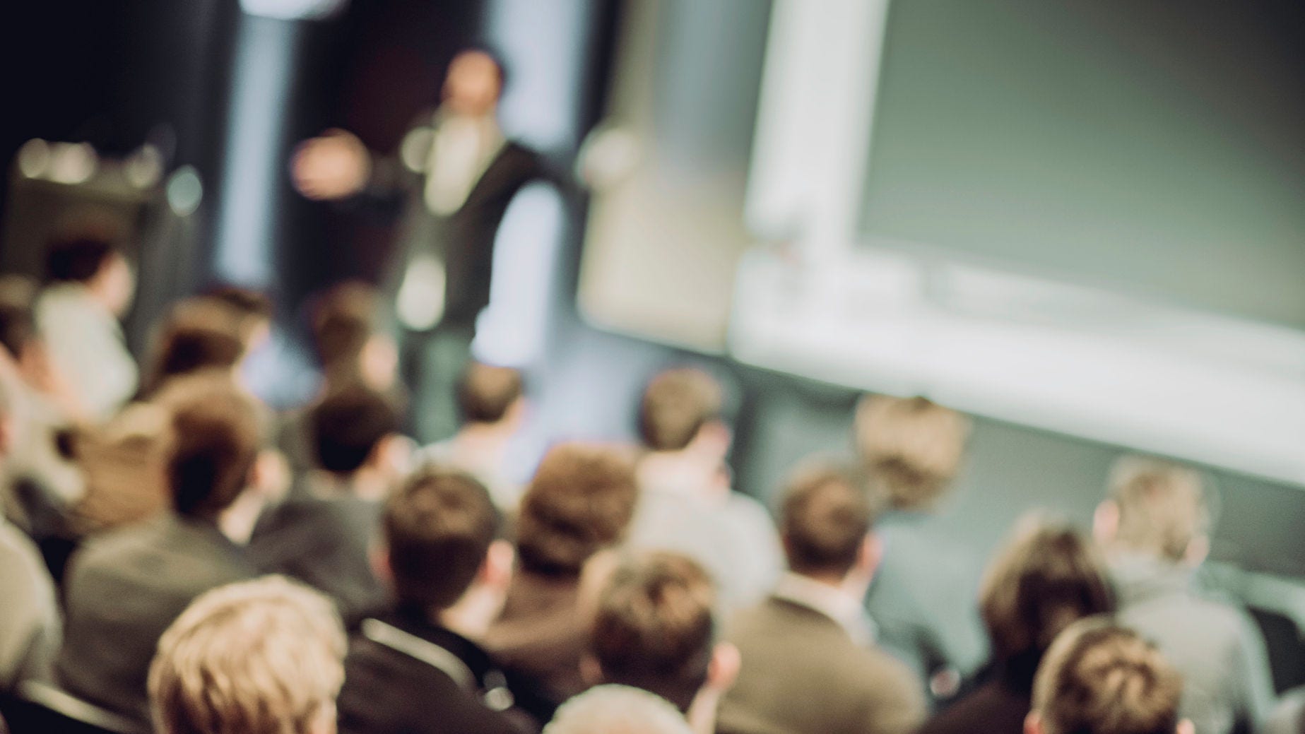 Defocused shot of crowd in the lecture hall. Purposely blurred with a lens.