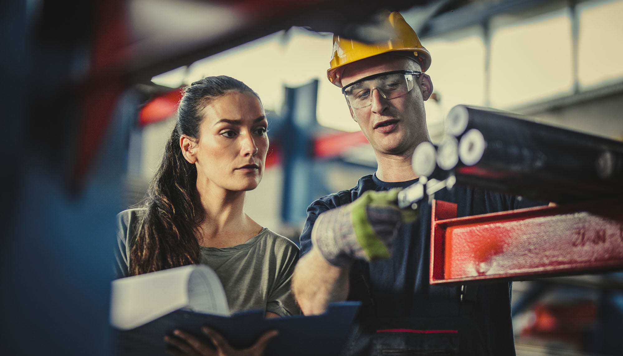 man working in a factory showing woman his work