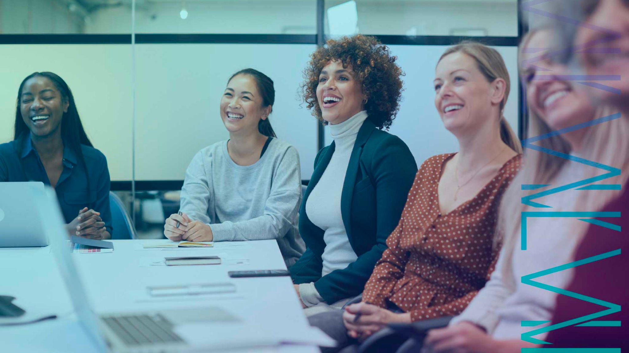 Group of smiling women around a conference table