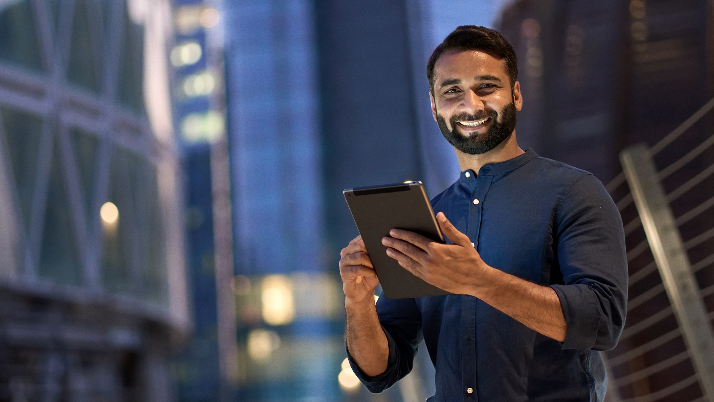 Guy smiling with an ipad in his hand