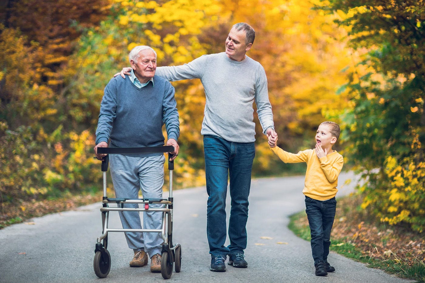 father, son, and grandparent walking in the woods together