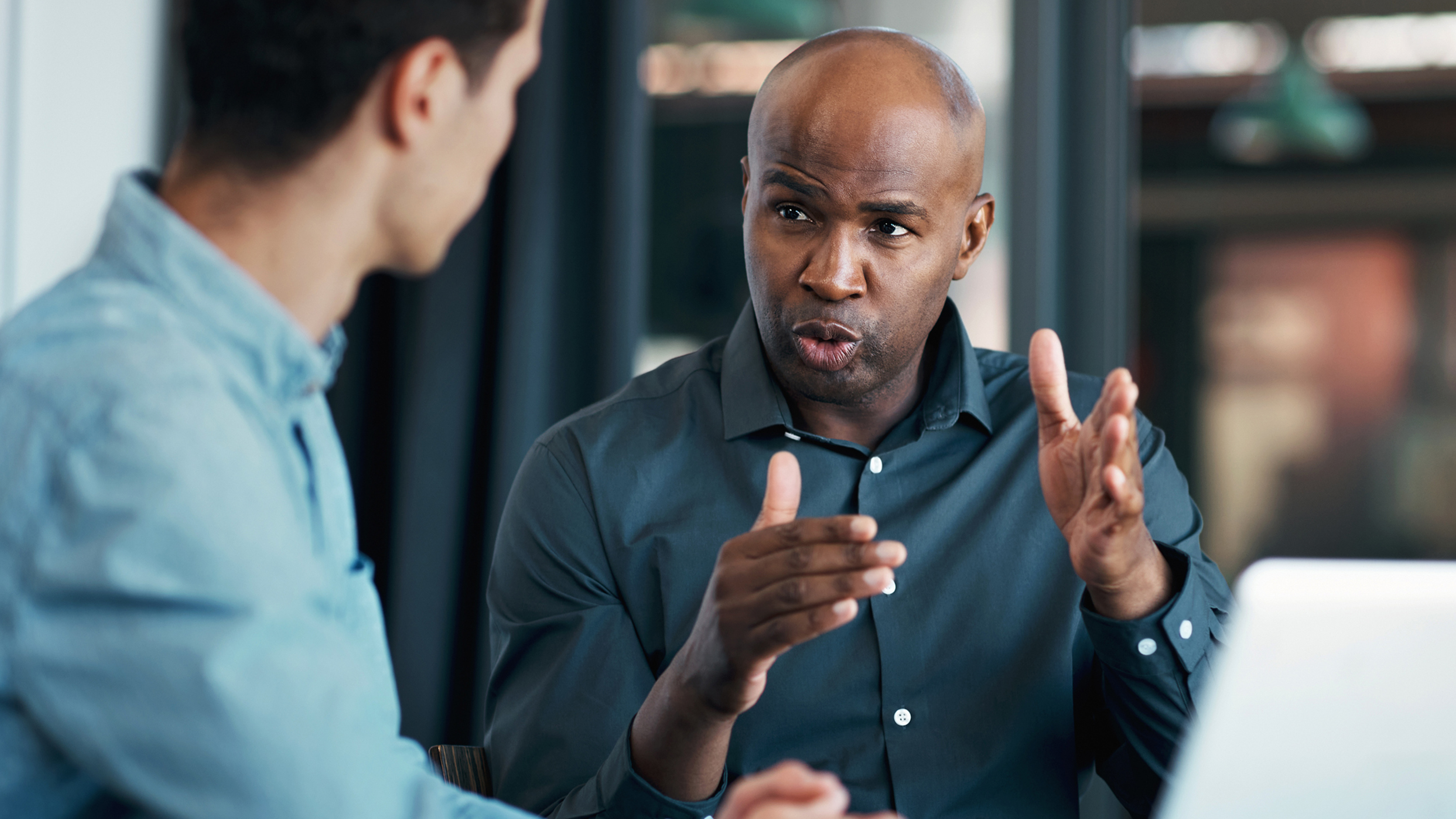 two men speaking in an office