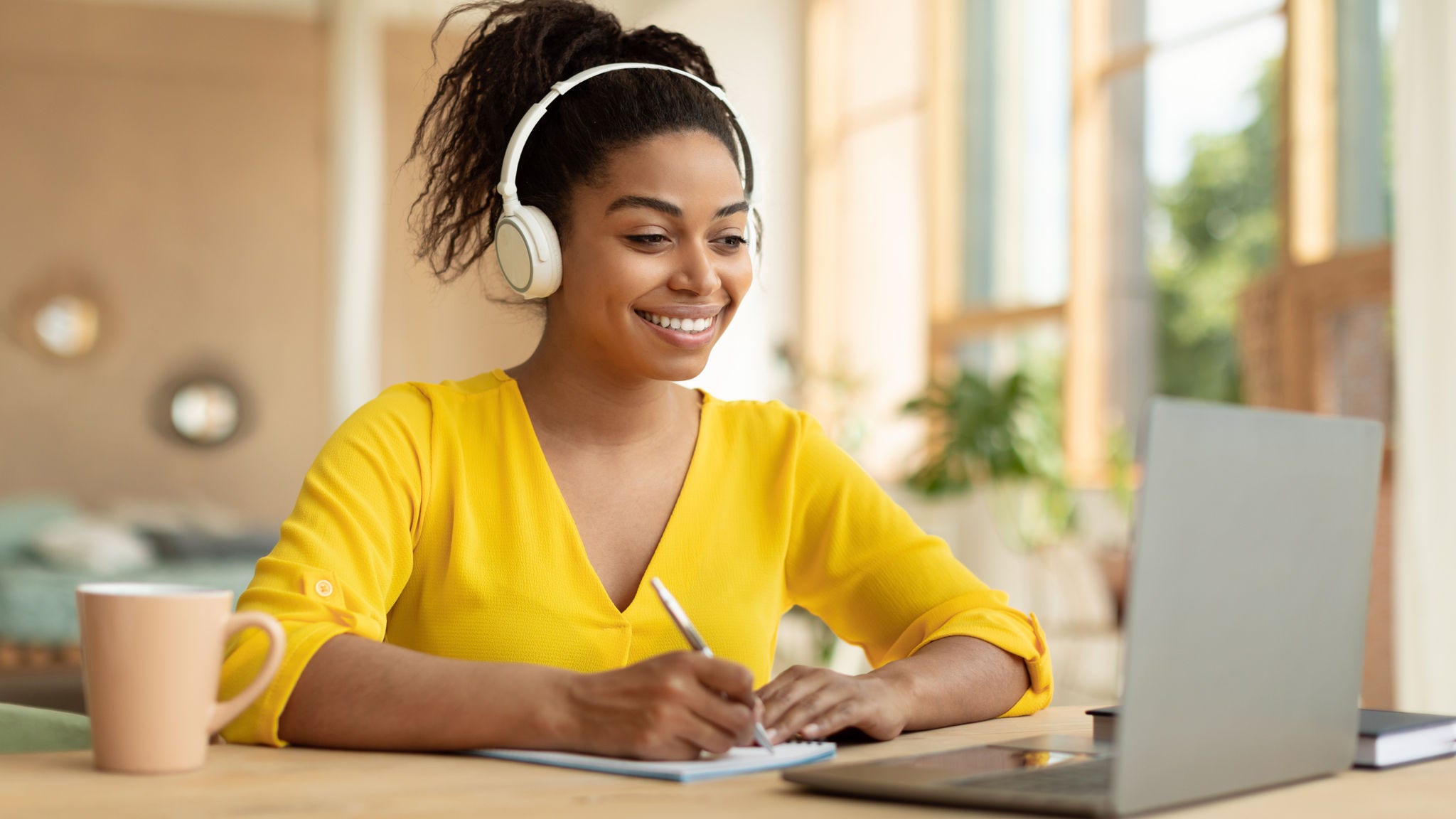 Woman watches eLearning and takes notes