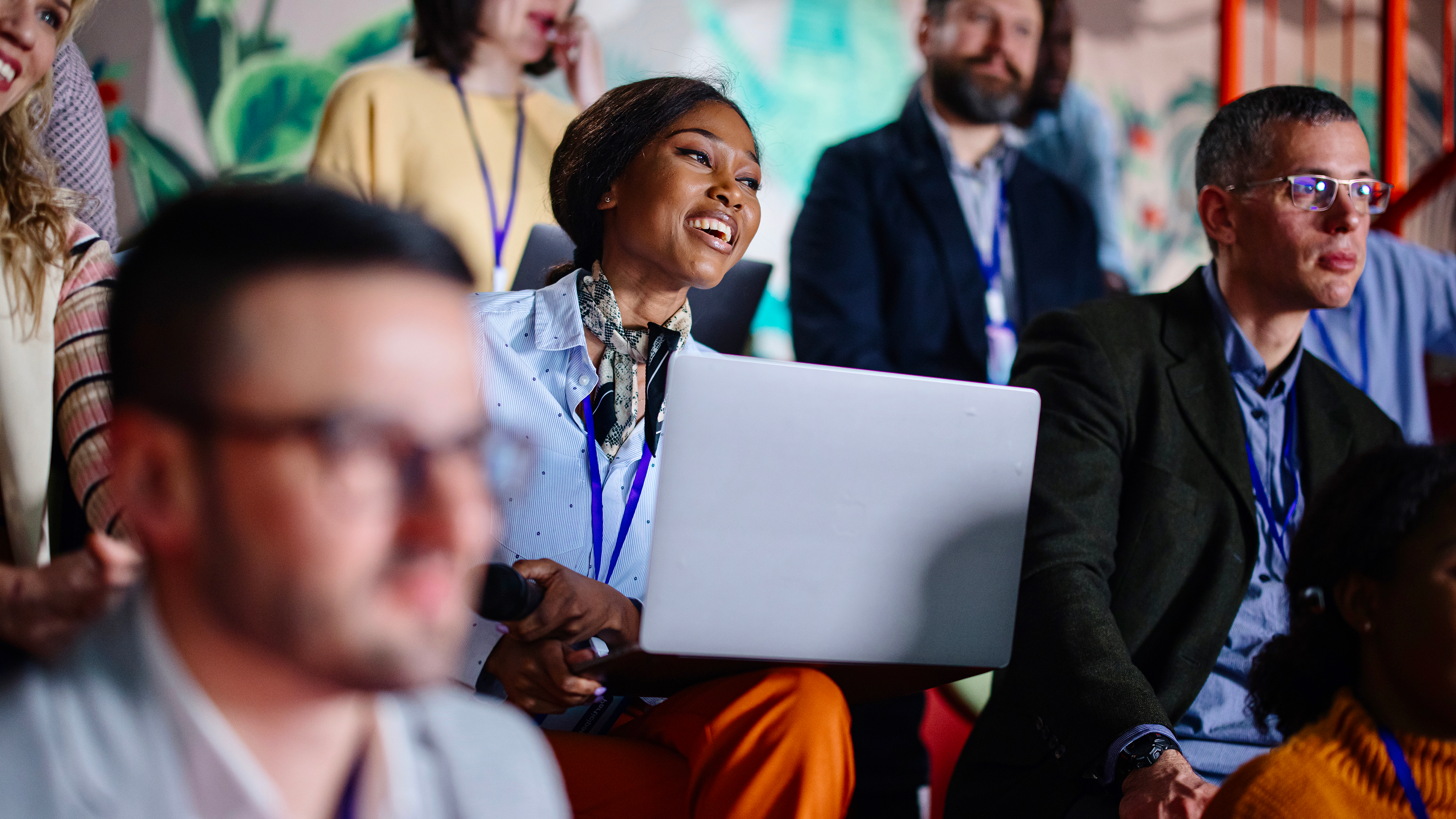 woman holding laptop in a group of seated people