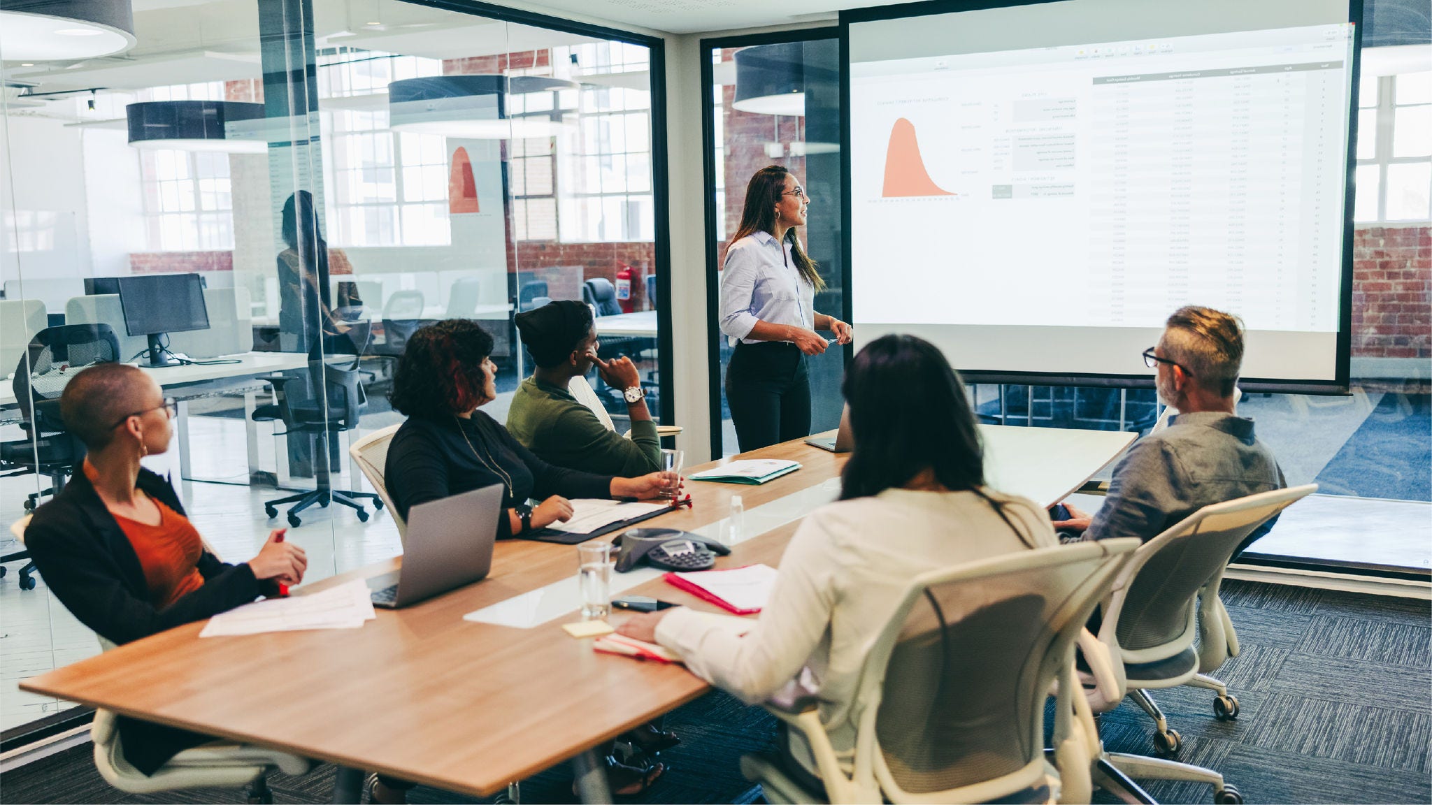 Group of employees in conference room looking at presentation