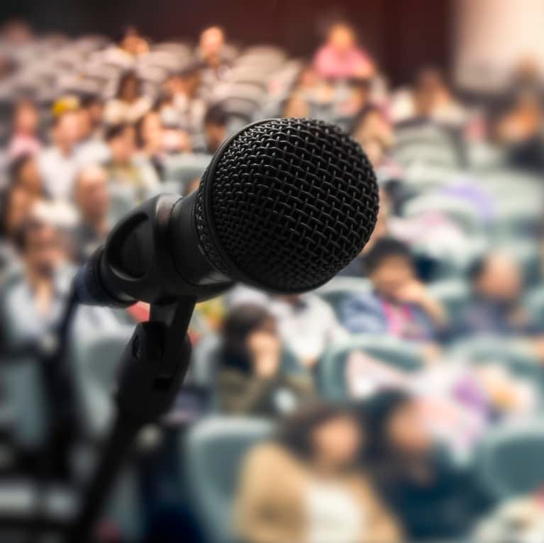 Up close microphone with blurry crowd in background Up close microphone with blurry crowd in background
