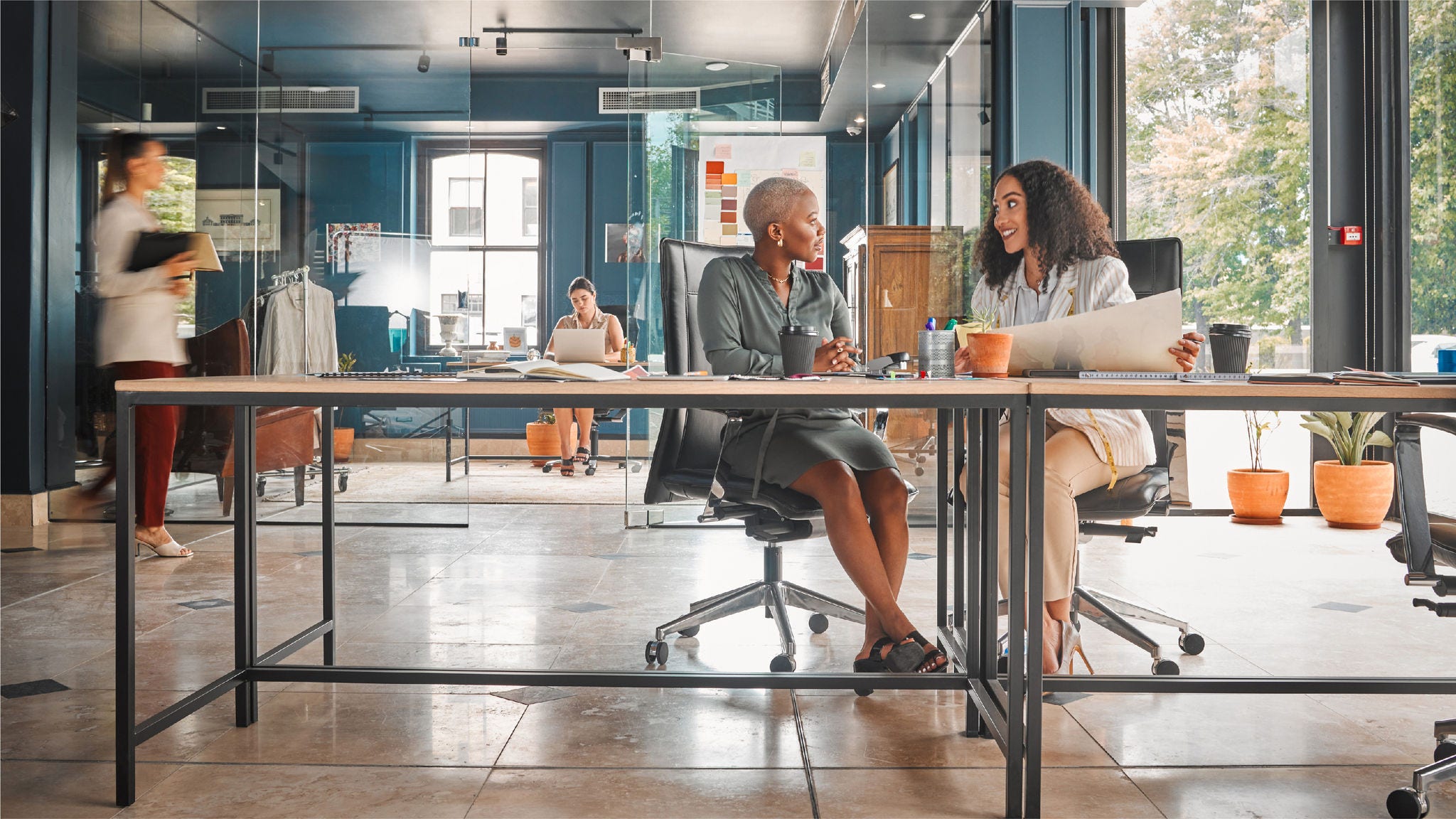 Two colleagues collaborate in an open format workspace. 