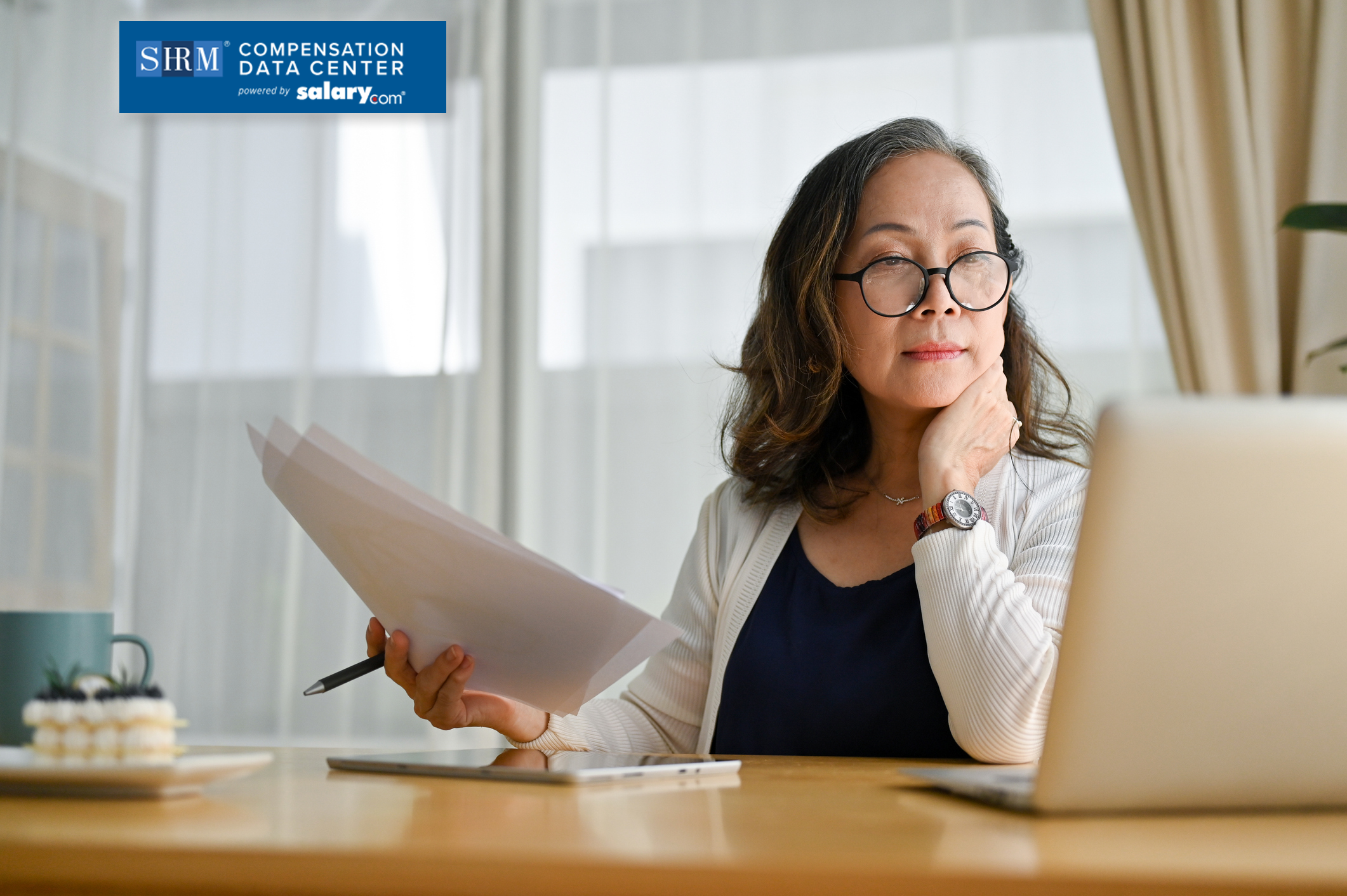 Lady Analyzing in laptop and with papers and pen in her hand