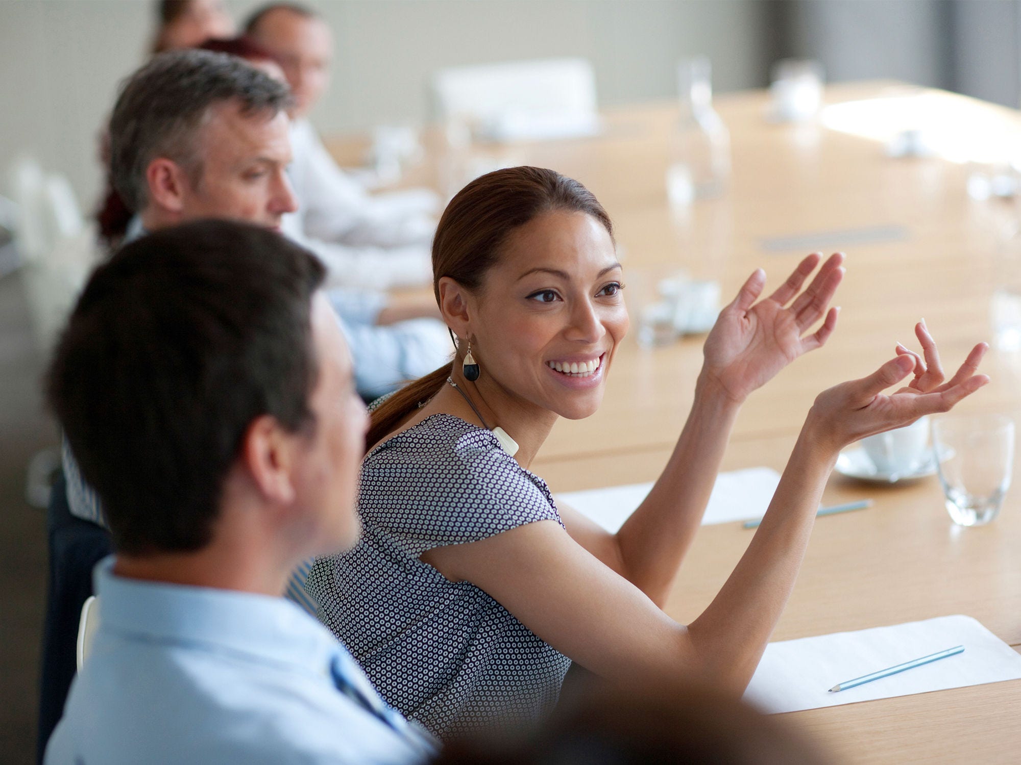 171096016 Woman smiles while speaking during a meeting.