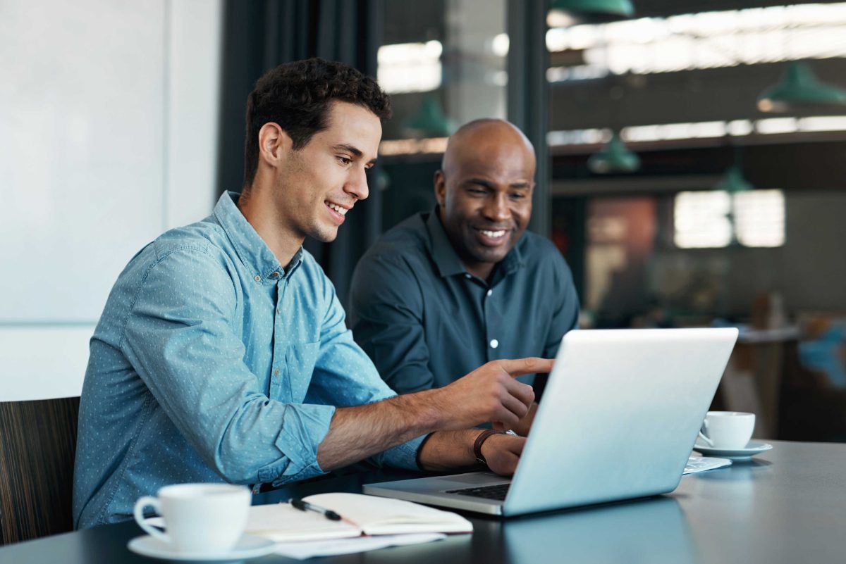 man pointing at laptop with coworker