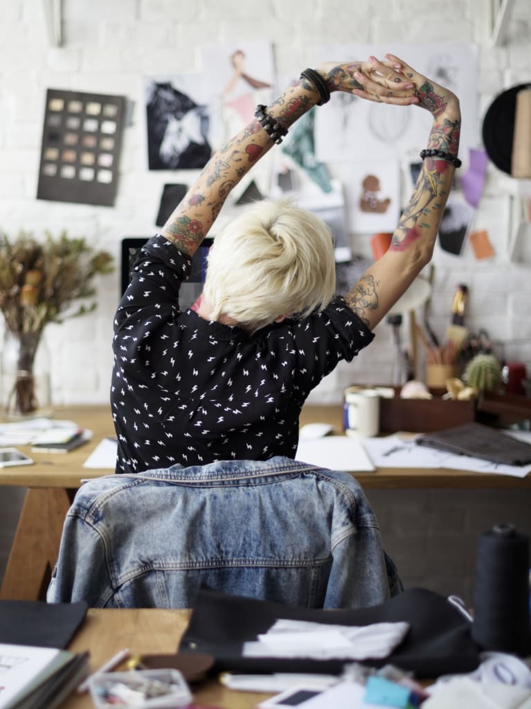 Photo of woman with tattoos on her arms.
