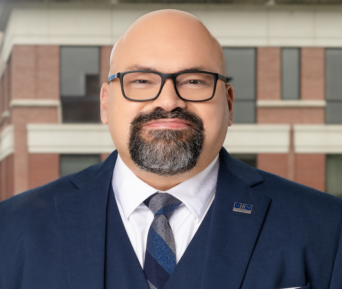 Alex Alonso facing the camera straightforward in a blue suit