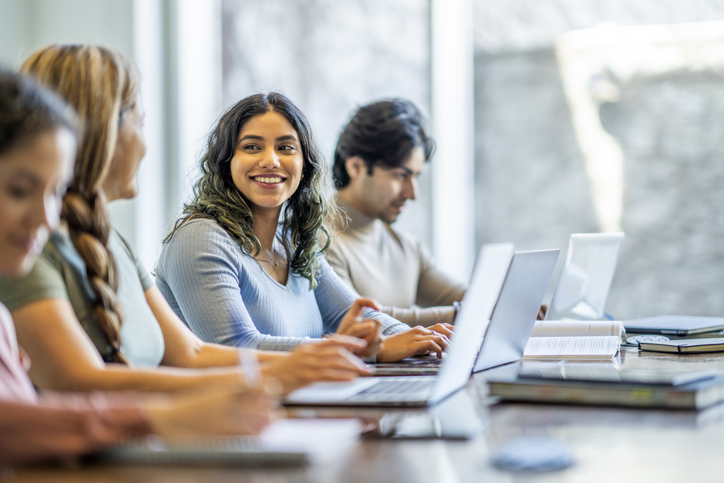 female student smiling sitting in front of laptop