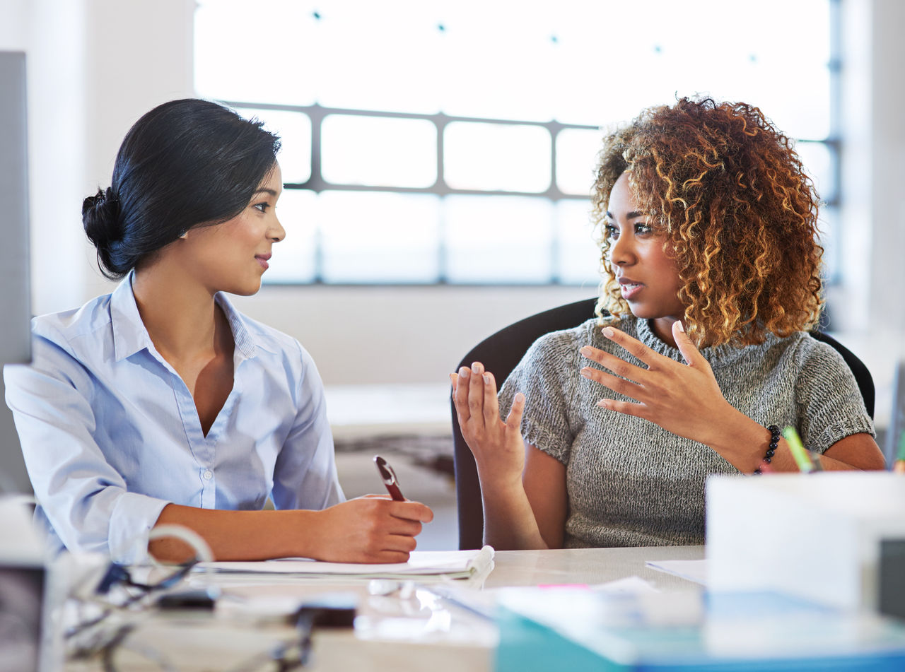 female employees sitting around a table discussion mental health