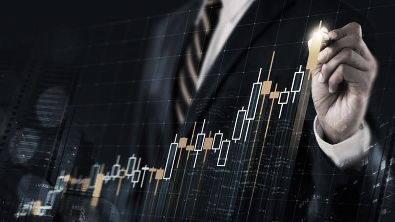 A businessman in a suit is holding up a stock chart.