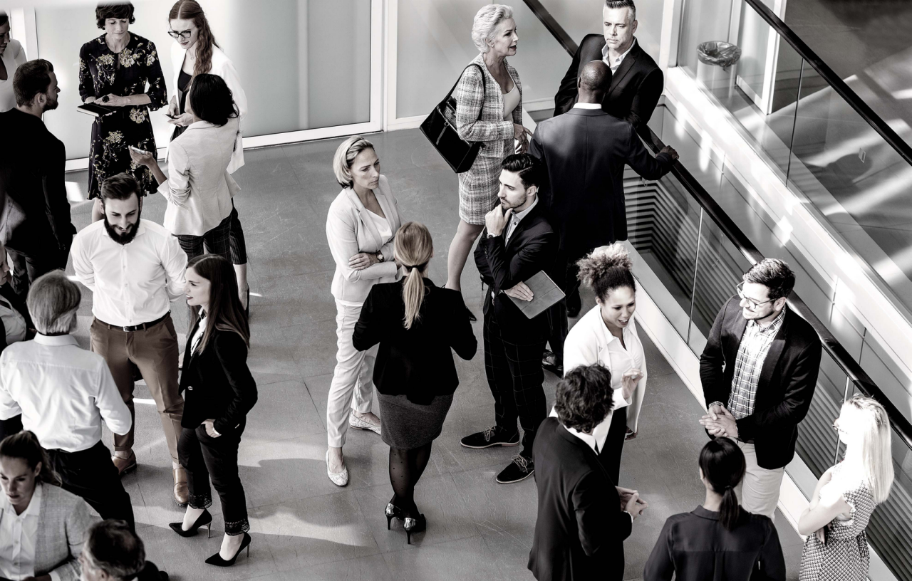 Image of coworkers standing in hallway talking.