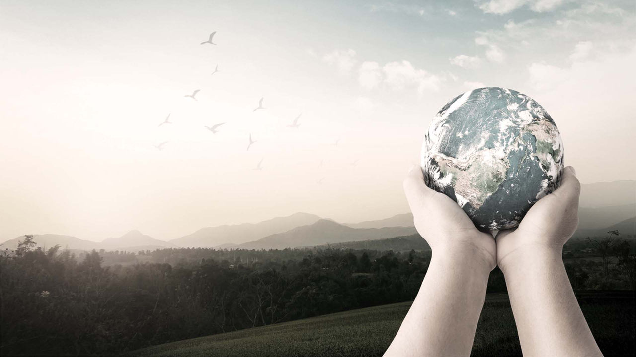 A woman is holding a globe in her hands.
