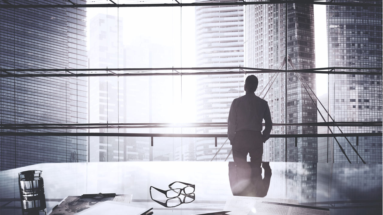 executive looking out office window