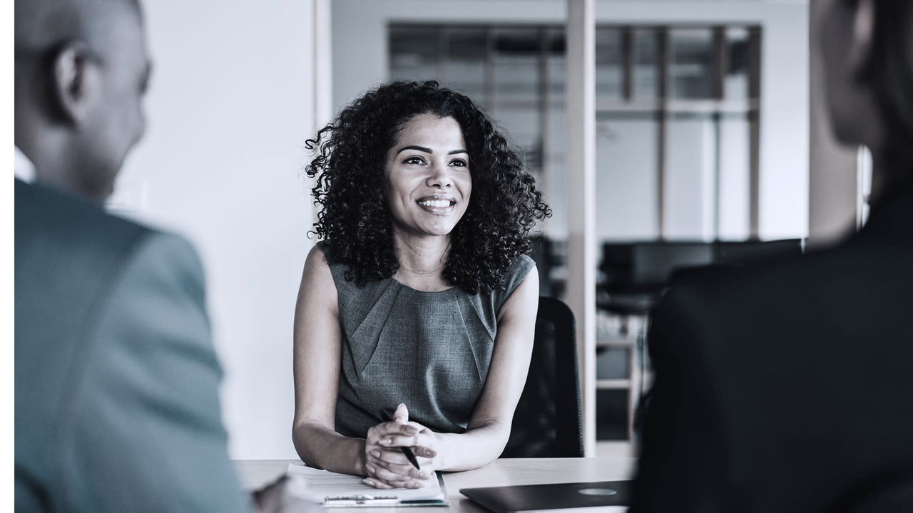 A woman is talking to a man in a business meeting.