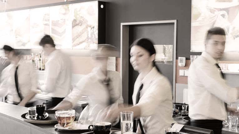 A group of waiters and waitresses working at a restaurant.
