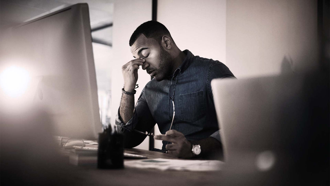A man is sitting in front of a computer screen.