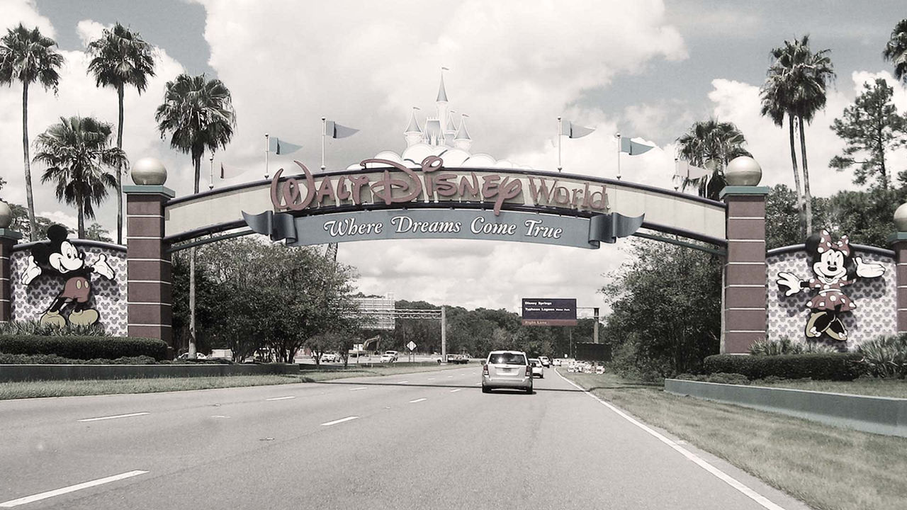A black and white photo of the entrance to disney world.