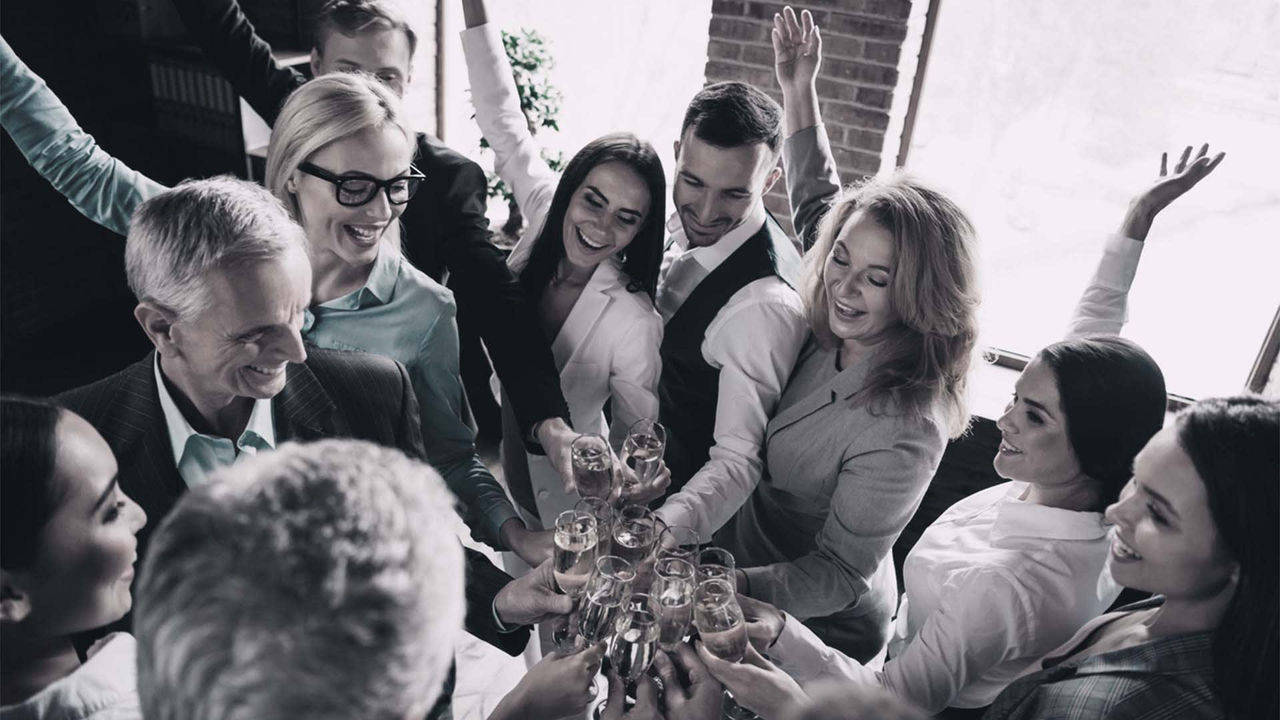 A group of business people holding champagne glasses.