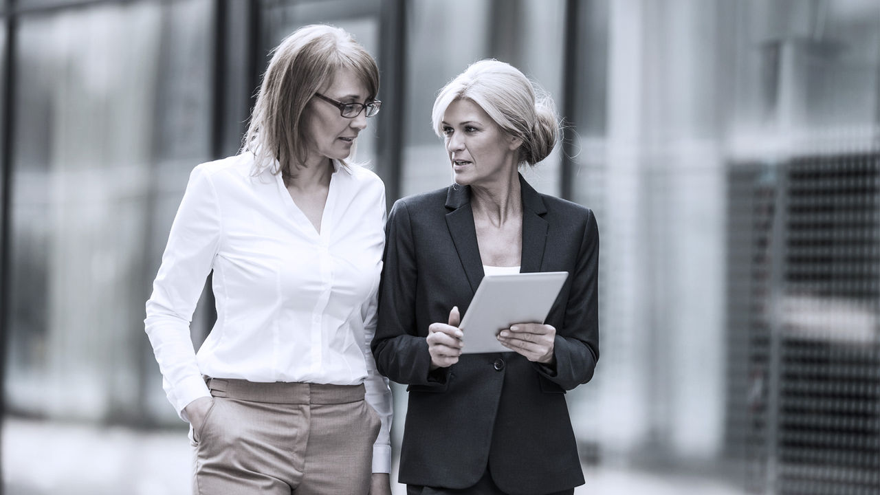 two business women walking and talking outside the office 