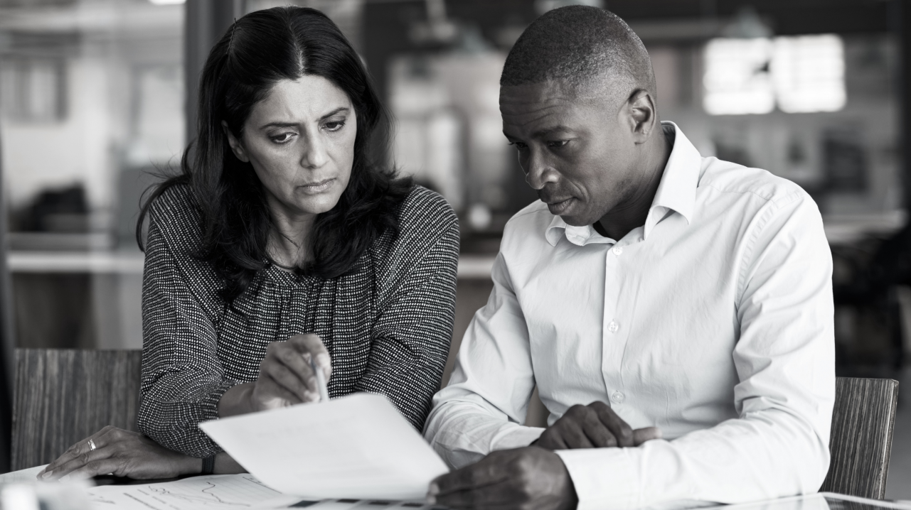 Two professionals reading documents
