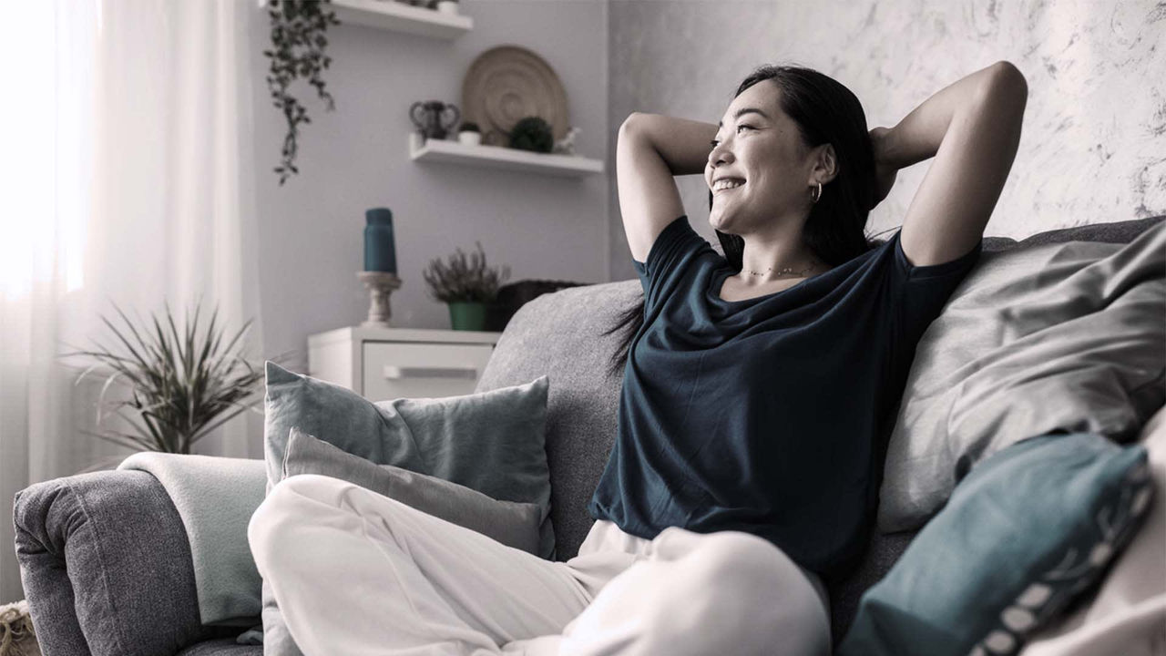 A woman is sitting on a couch in her living room.