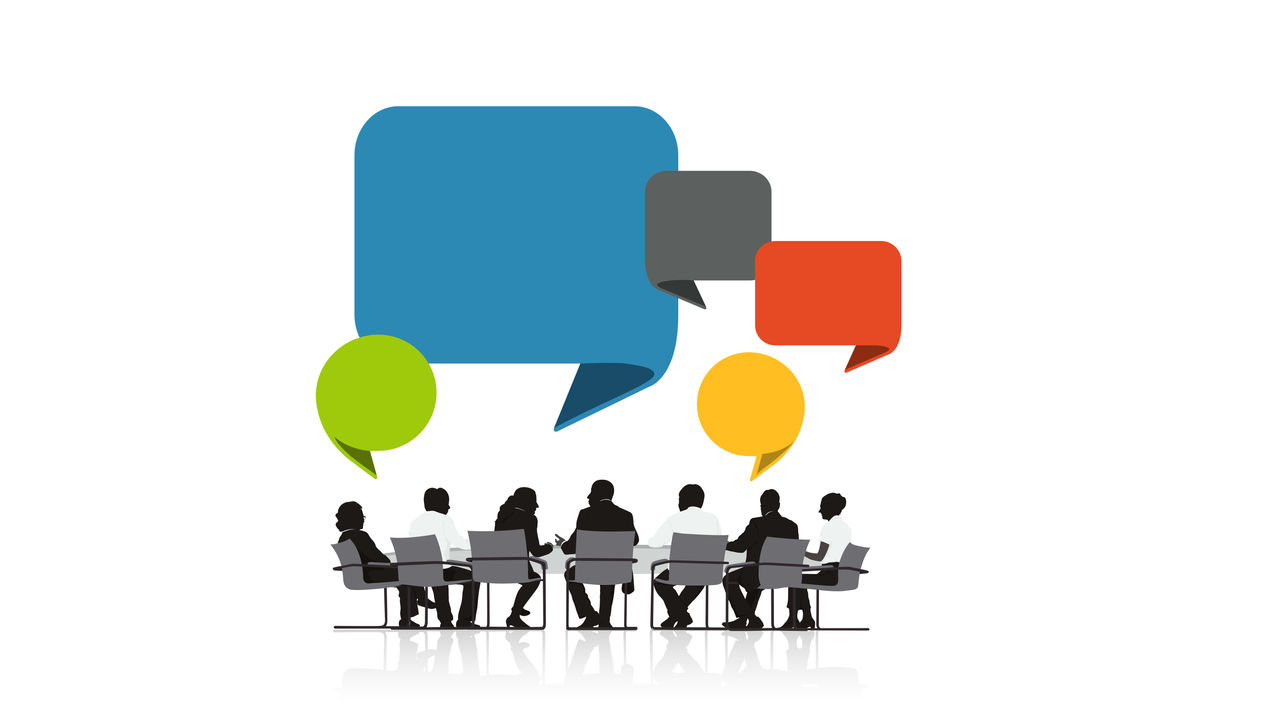 A group of people sitting at a table with speech bubbles.