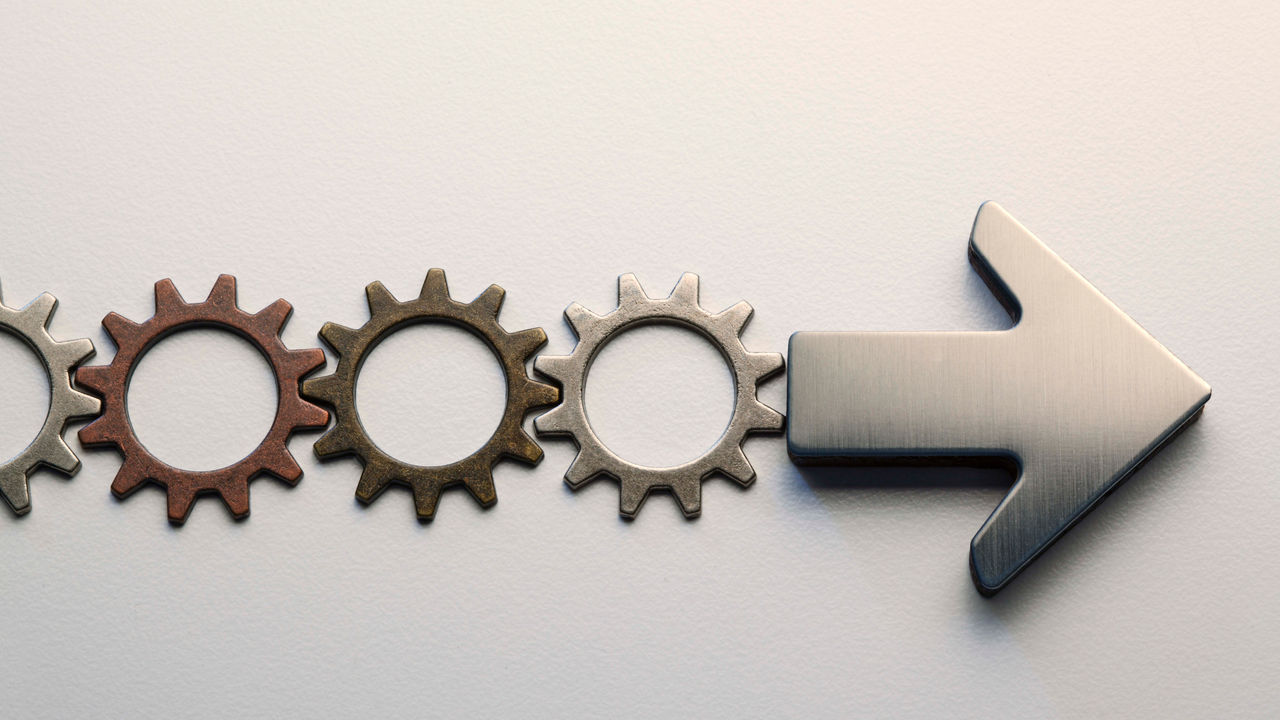 A group of gears with an arrow pointing to the right.