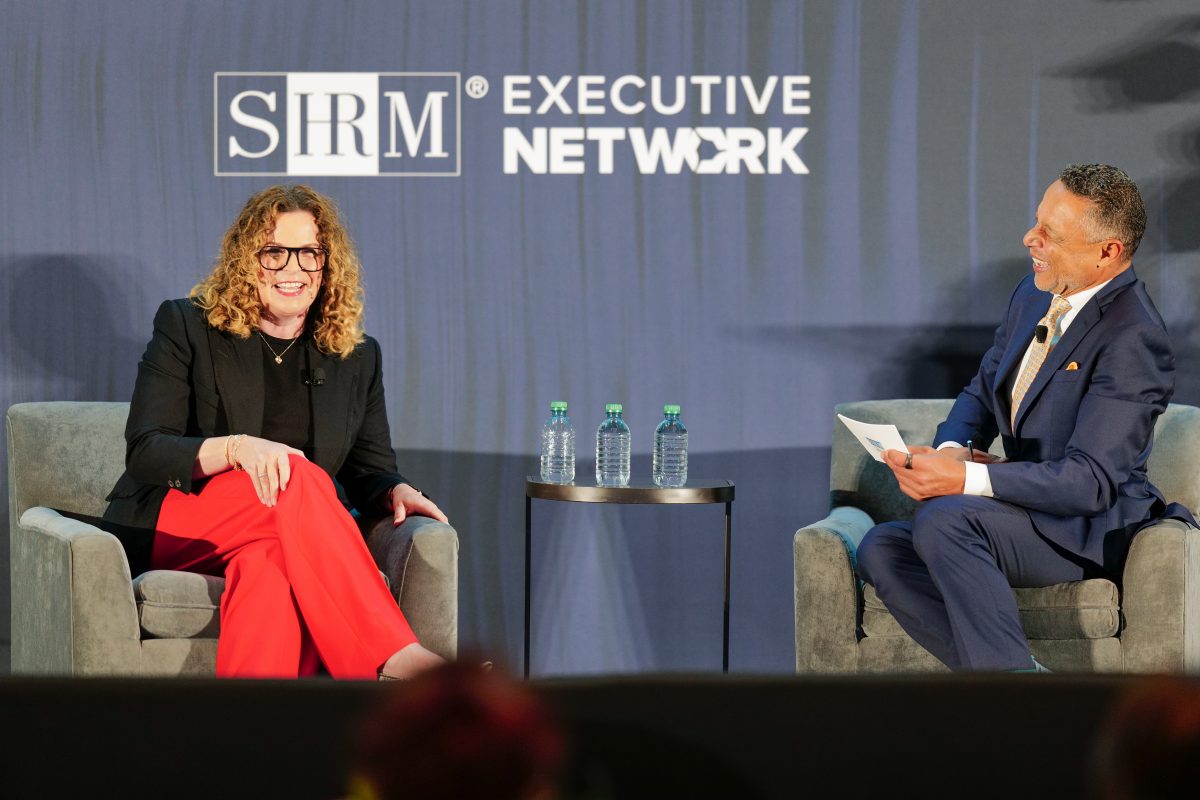 Podcast host Mo Fathelbab (seated on the right) and podcast guest Claire MacIntyre (seated on the left) on stage at the Visionaries conference.
