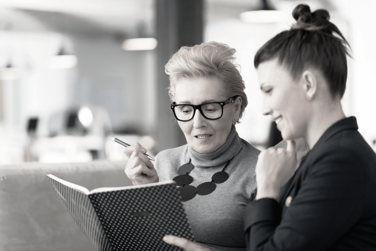 two employees looking at book in office