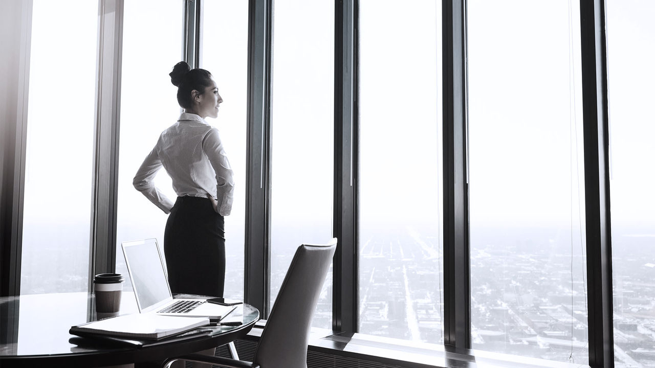 A business woman looking out of a window.