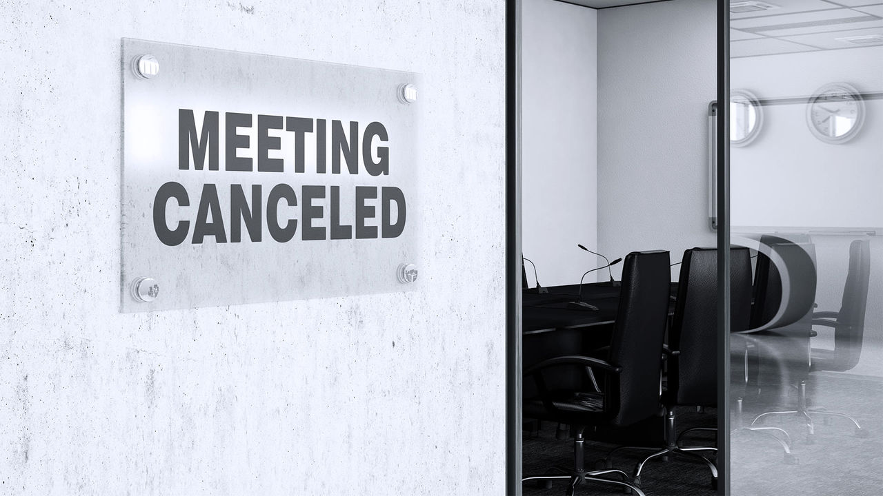 A sign that says meeting cancelled in a conference room.