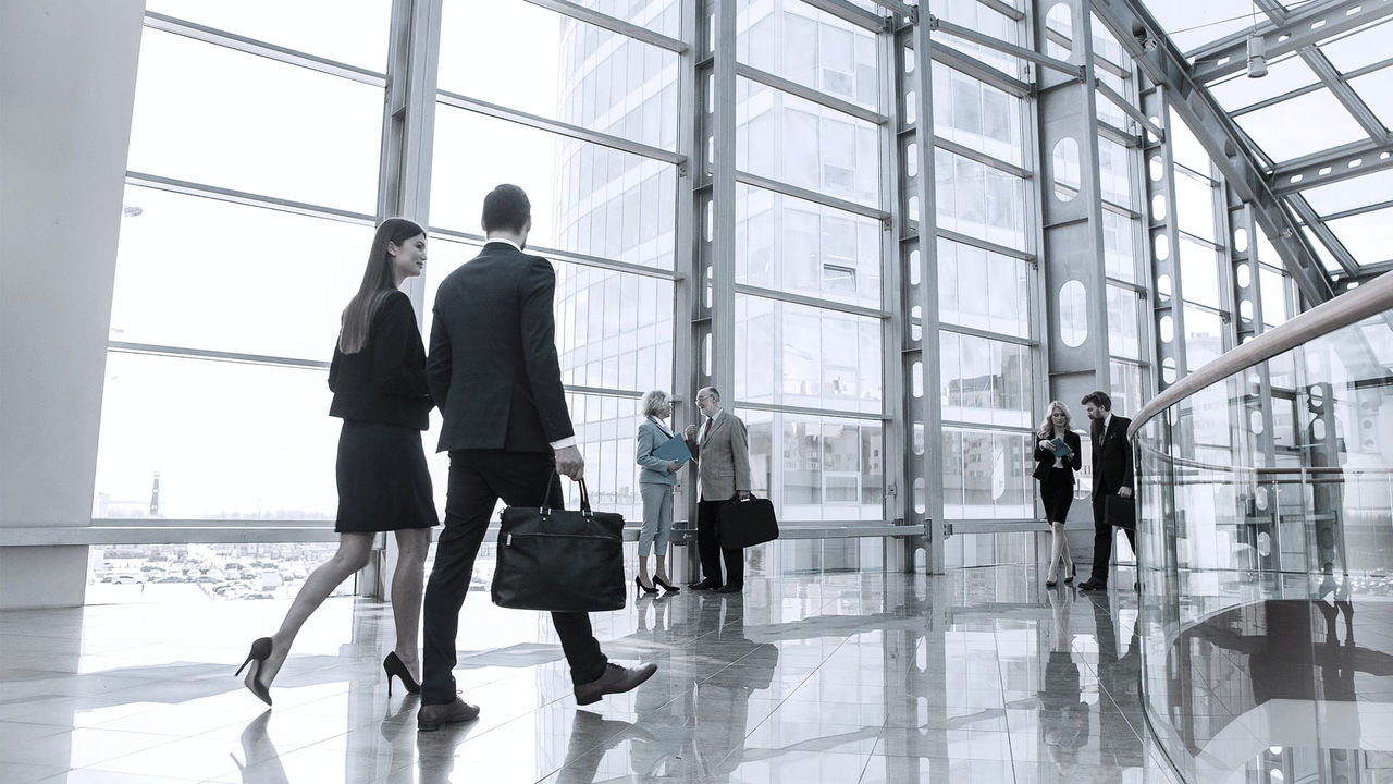 A group of business people walking in an office building.
