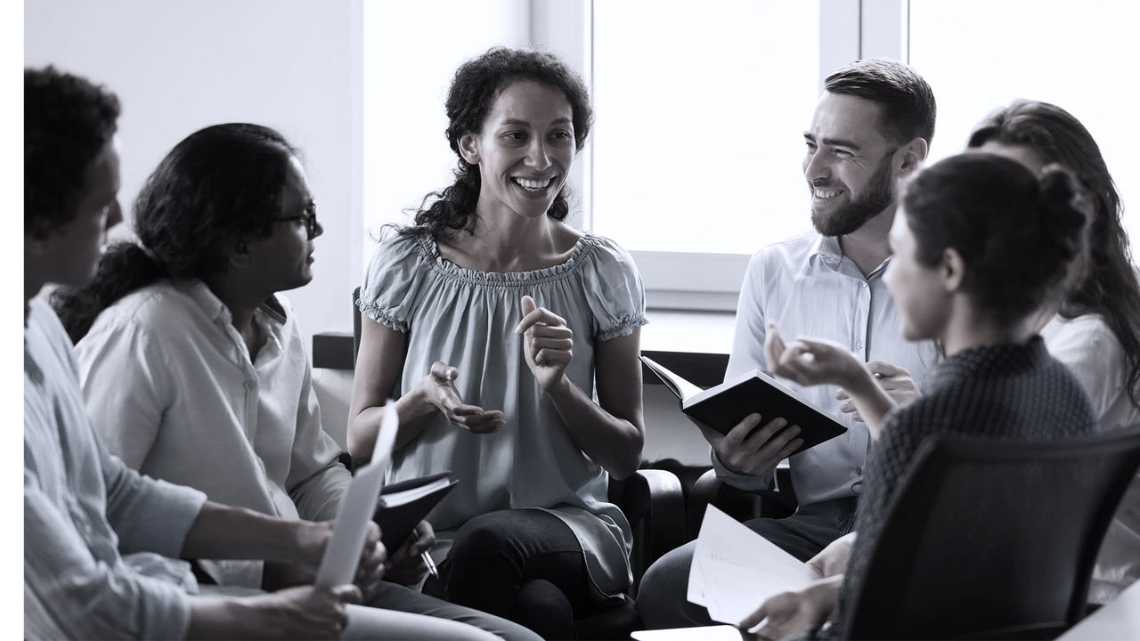 A group of people sitting around a table talking.