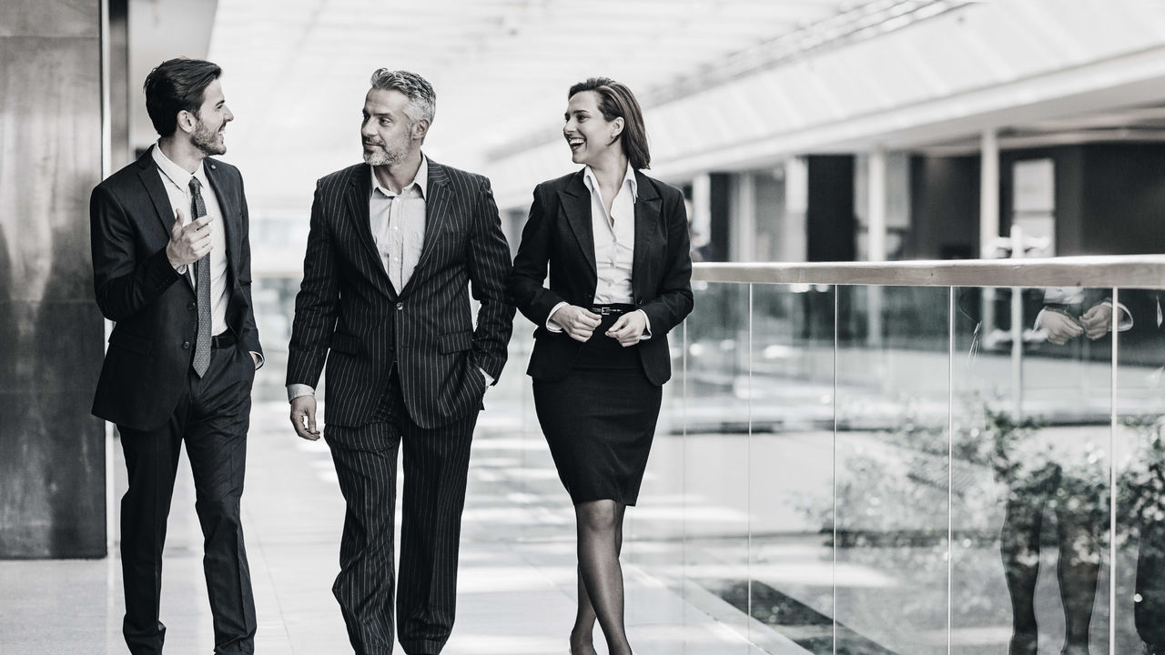 Black and white photo of a group of business people walking.