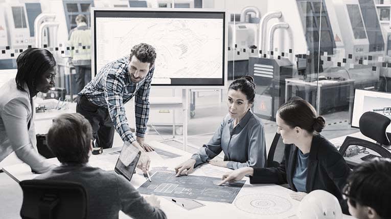 A group of people sitting around a table in an office.