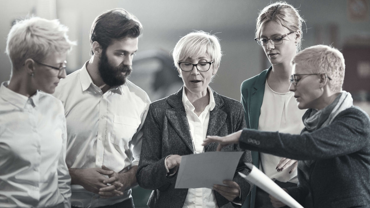 A group of business people looking at a piece of paper.