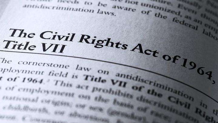 Book text displaying an explanation of the Civil Rights Act of 1964 and Title VII